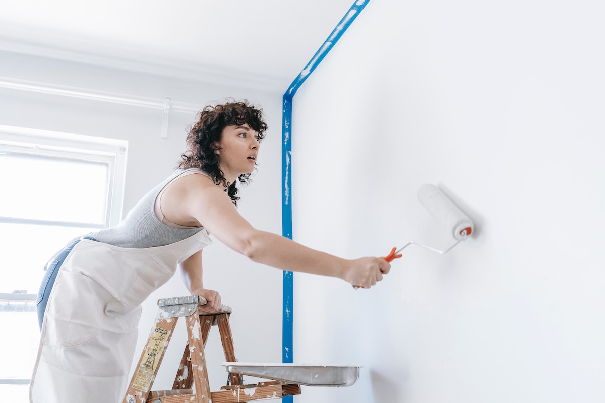Woman painting a room before selling her house as-is